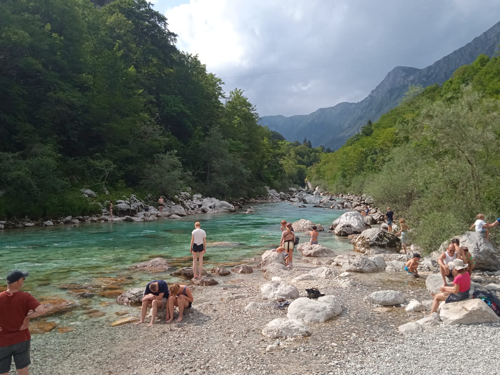Famiglie e gruppi di turisti che si rilassano lungo le rive del fiume Isonzo, Slovenia.